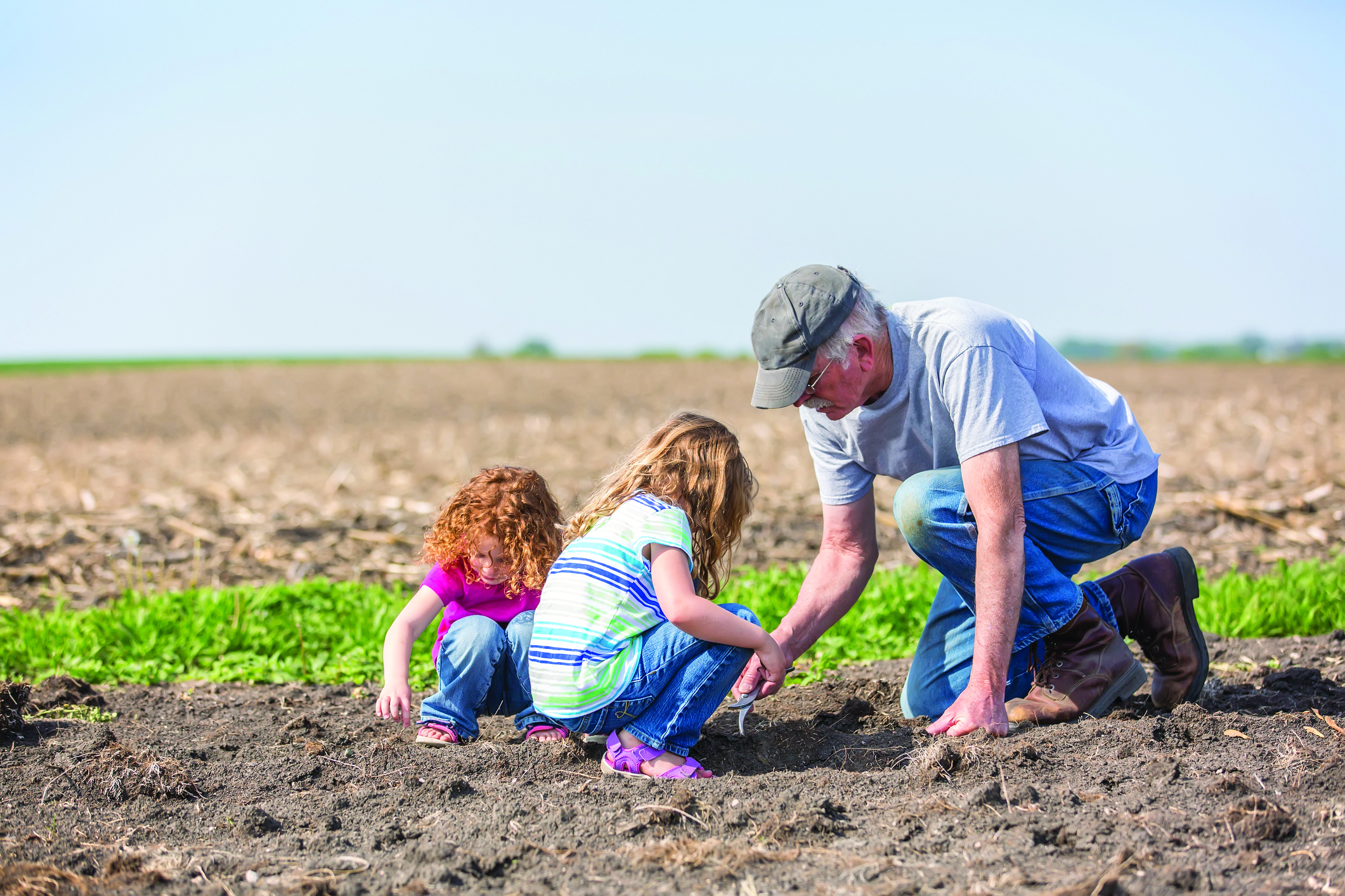 Farmer in field with grandchildren